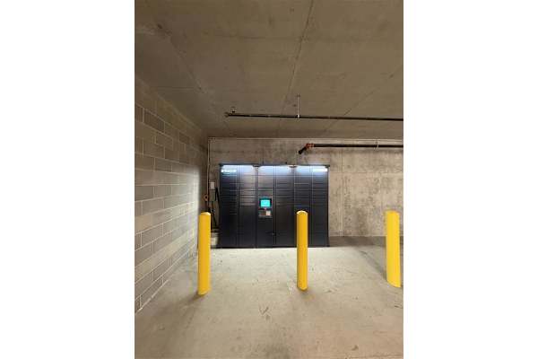 A concrete room with a black door and yellow bollards. at The Revival, Salt Lake City, 84101